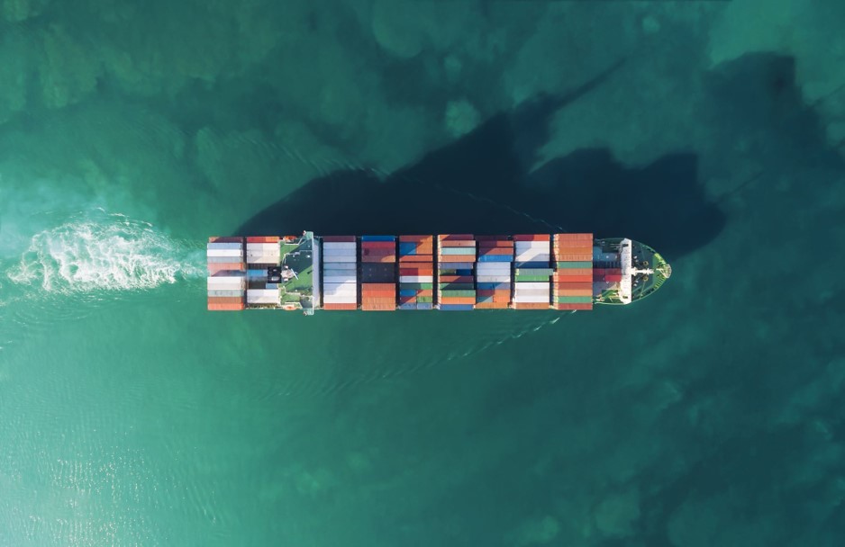 Aerial photo of a cargo ship in teal blue waters